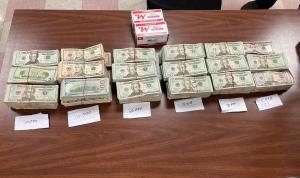 Stacks containing $159,531 in unreported currency and boxes containing 200 rounds of ammunition seized by CBP officers at Brownsville Port of Entry.