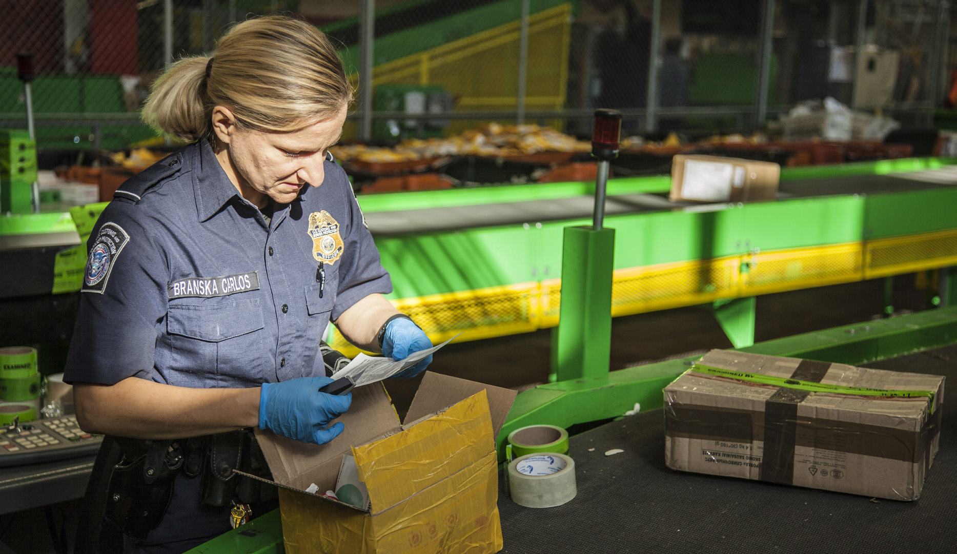 CBP Officer Monika Branska Carlos inspects a package with possible illegal narcotics.