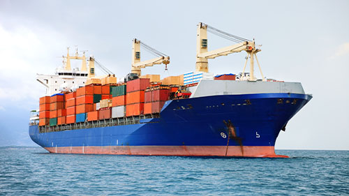 Cargo vessel in ocean carrying cargo containers.