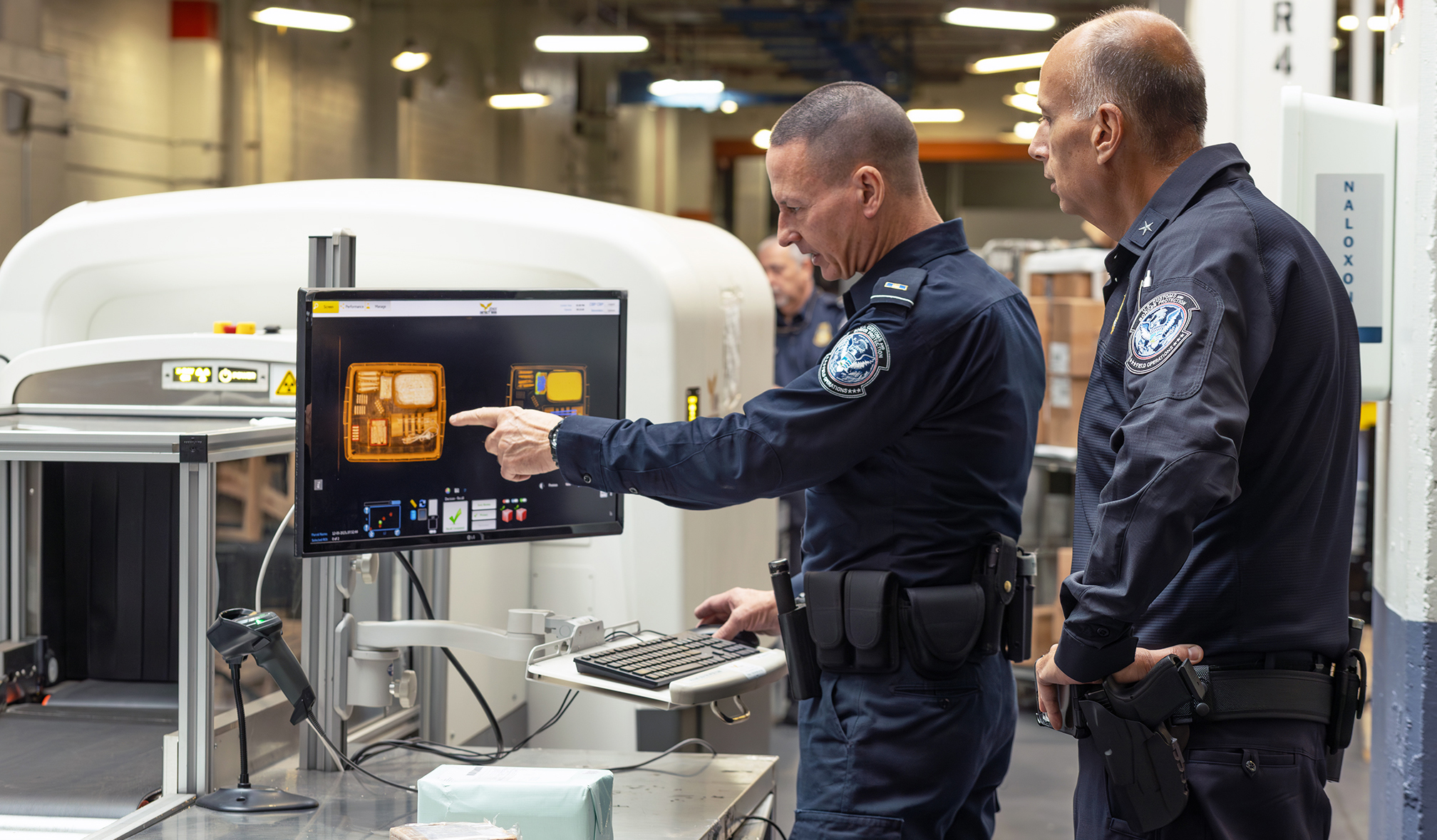 CBP personnel look at suspicious merchandise in a de minimis package