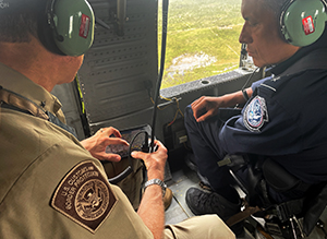 CBP Lead Field Coordinator Carlos Martel (right) is briefed by Keith Kincannon, Deputy Director, CBP’s Miami Air and Marine Branch during an overflight of Hurricane Milton damage on Oct. 11, 2024.