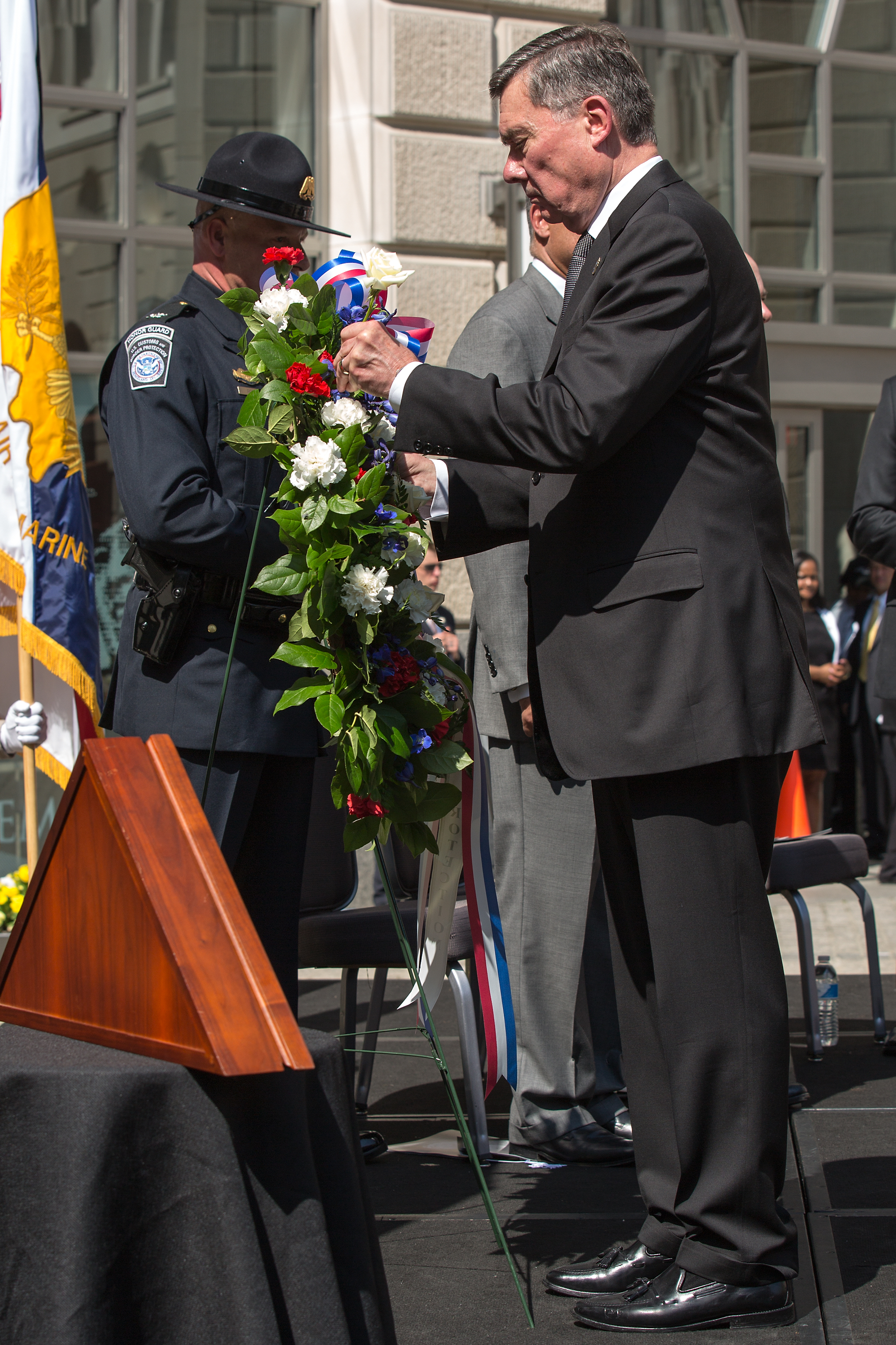 At the May 2014 CBP Valor Memorial ceremony, Commissioner Kerlikowske places a flower in a wreath to honor CBP’s fallen employees. CBP Acting Deputy Commissioner Kevin McAleenan stands at right.