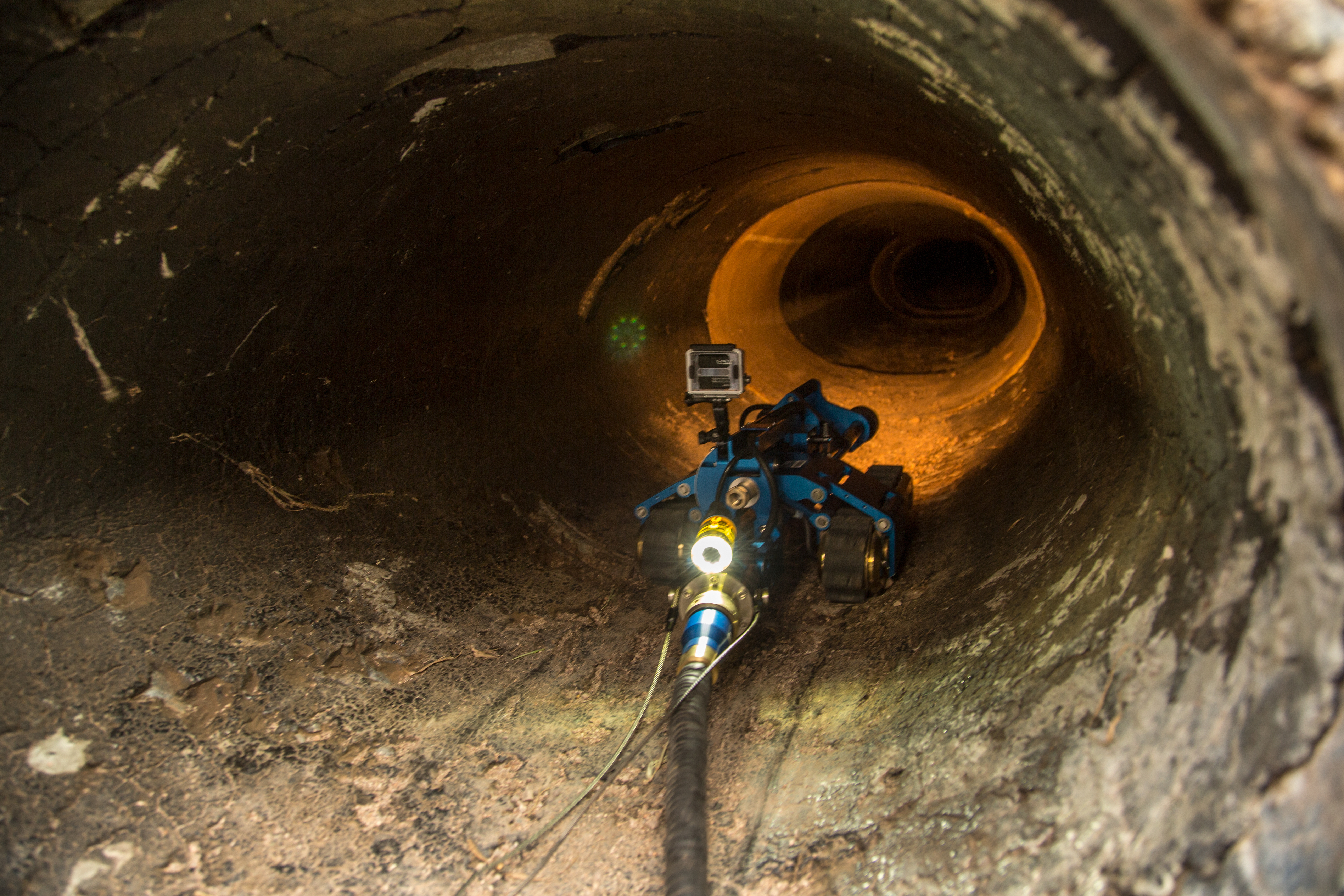 The CBP robot investigates an underground pipe and reports it's data back to agents above ground.