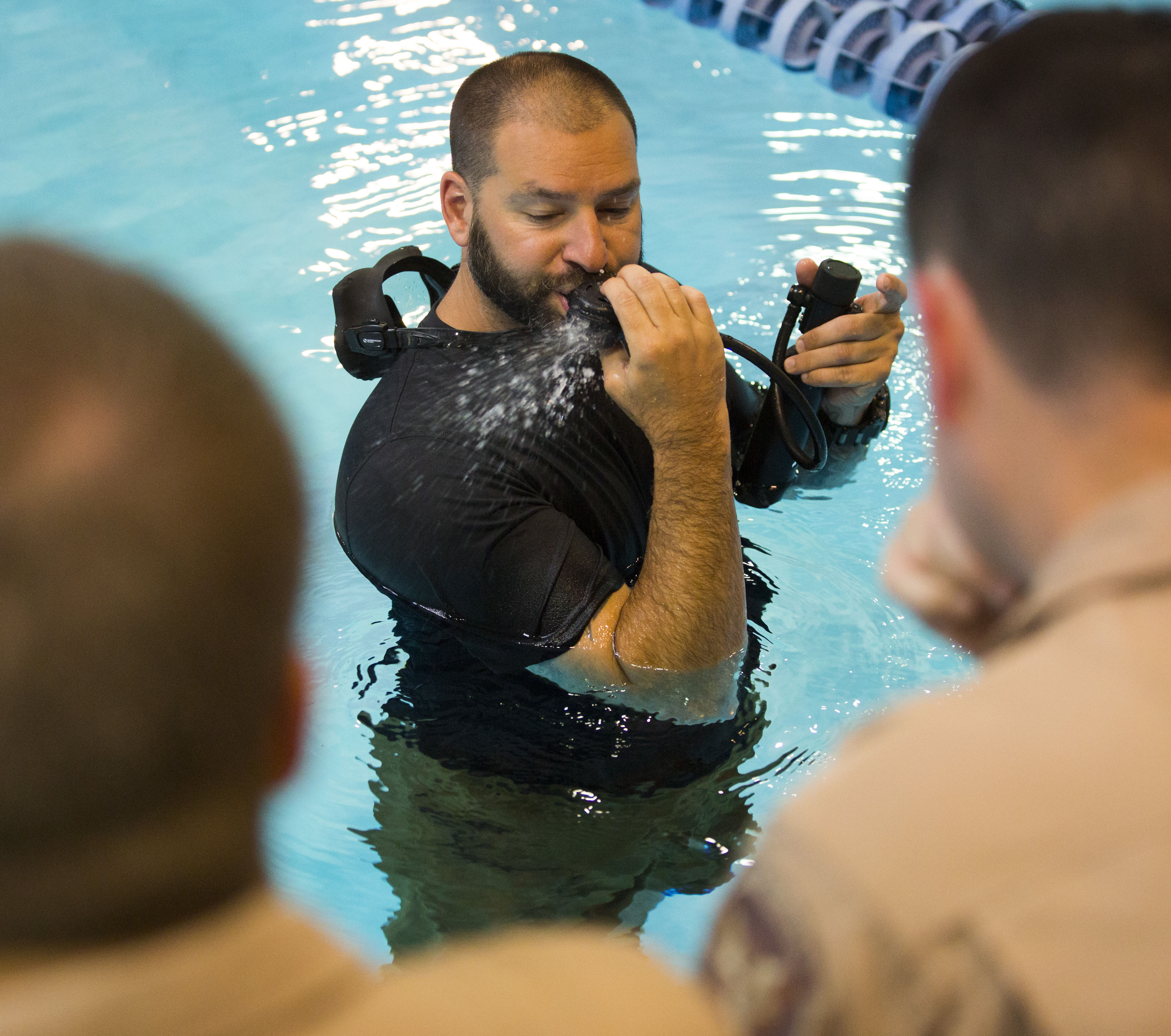 Instructor Chad Warren shows agents how to clear the mouthpiece of an air bottle while they’re underwater. 