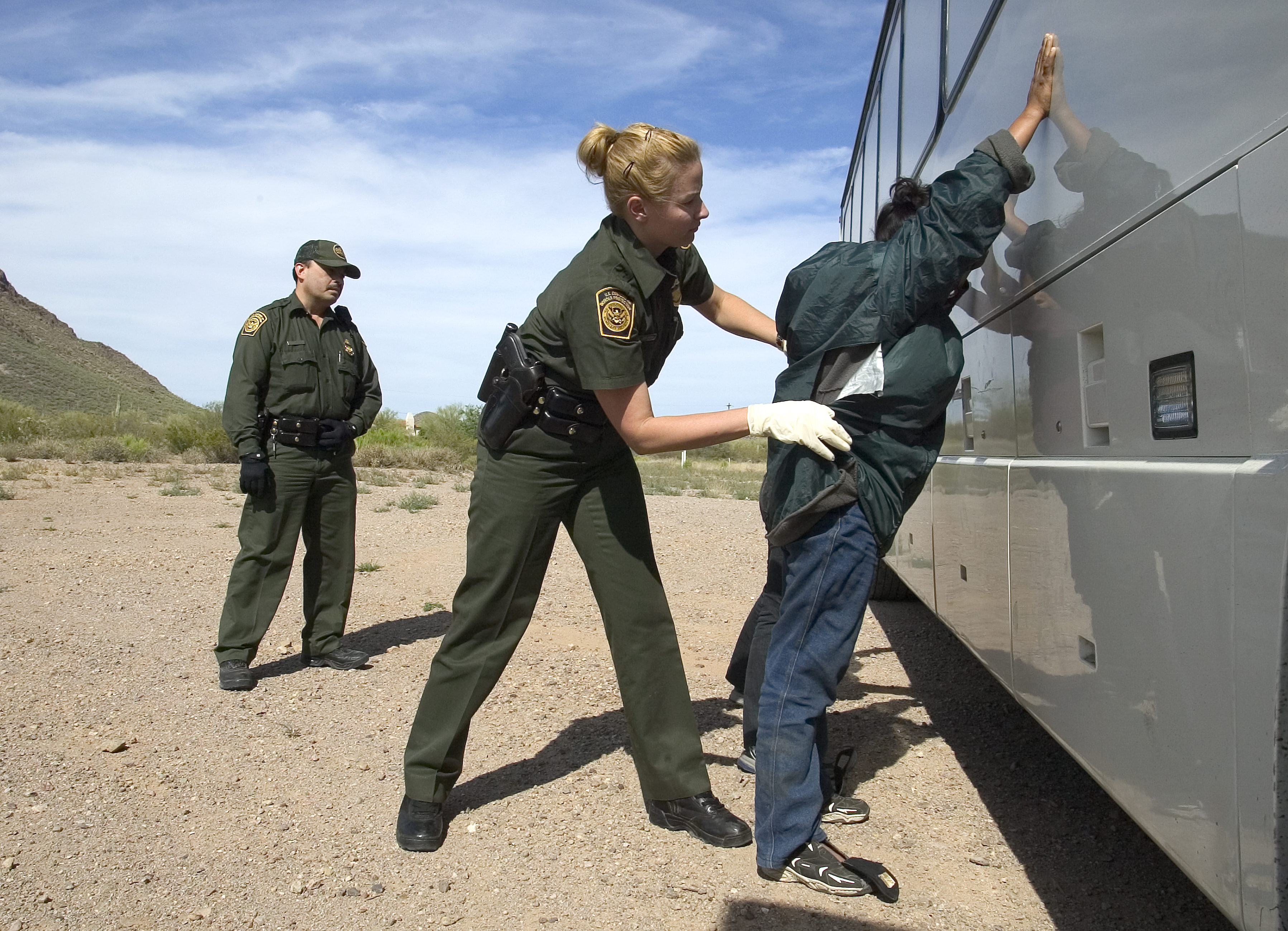 U.S. Border Patrol agent does a pat down of a female Mexican being returned to Mexico.