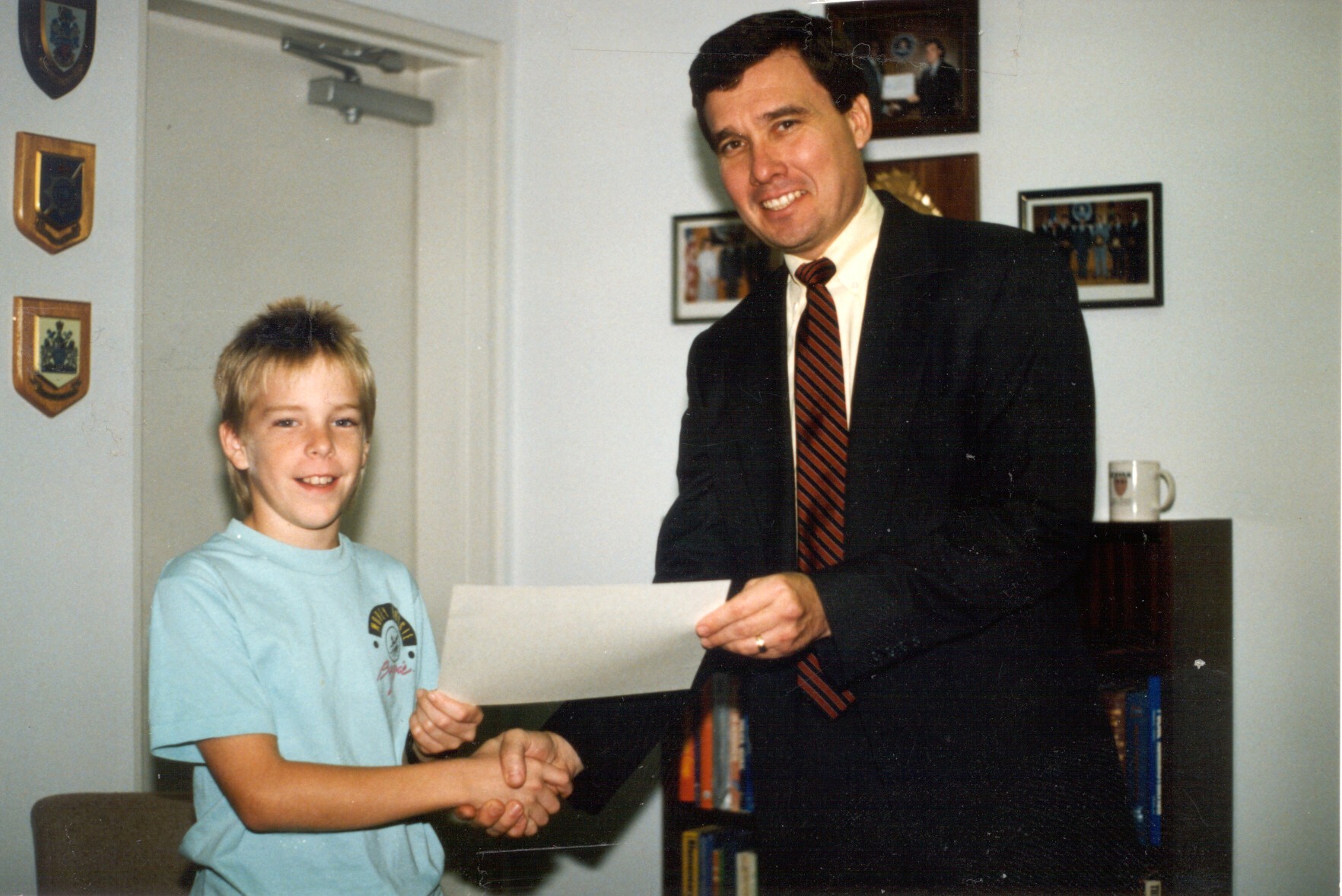 Photo of Kerlikowske presenting a certificate to a youngster chosen as Police Chief for a Day