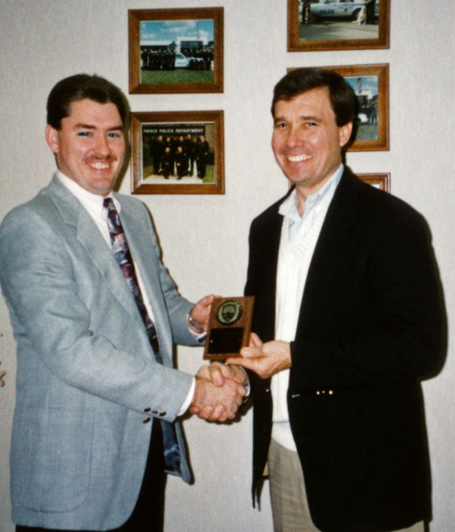 At the Fort Pierce, Florida, Police Department in 1993, R. Gil Kerlikowske, right, presents an award to R. Sean Baldwin, one of the first police officers that Kerlikowske hired and who now serves as Fort Pierce chief. "Chief Gil Kerlikowske was an innovative leader who left behind a legacy of community collaboration that still forms the foundation of our policing philosophy," wrote Baldwin for this article. Photo courtesy Fort Pierce Police Department