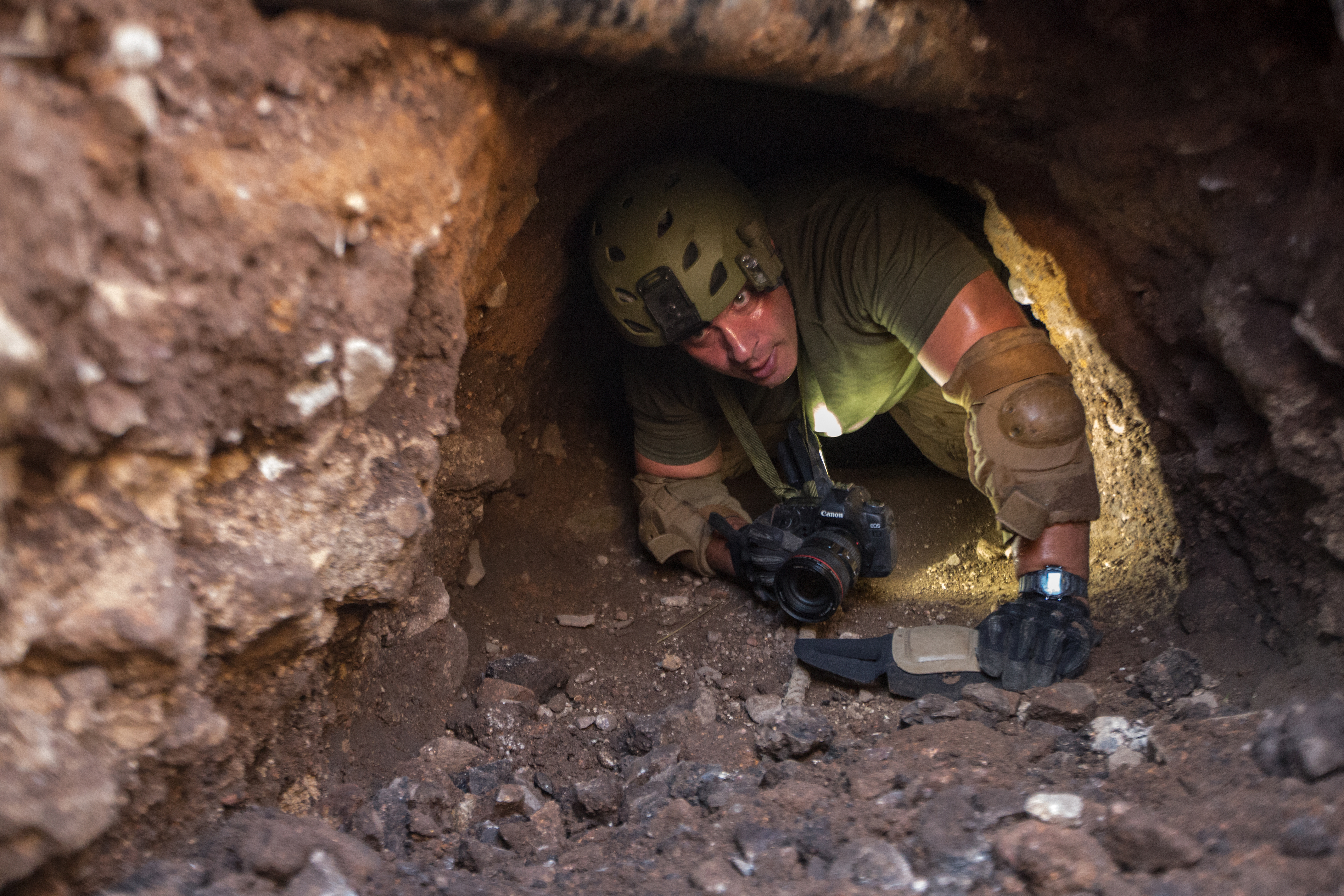 Border Patrol agent explores tunnel.