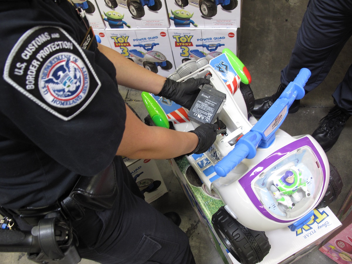 A CBP officer inspects a battery included in a child's toy vehicle.
