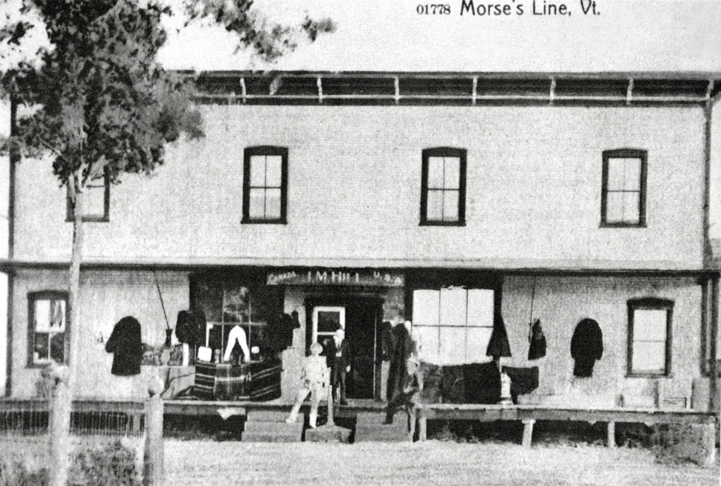 The second J. Morse line store when under the proprietorship of J.M. Hill, Jr. The store, which gave the hamlet the name Morses Line, straddled the international boundary. Boundary marker no. 621 is positioned in-between the two sets of steps, while the store sign overhead indicates the "Canada" side and "U. S. A." side of the building. This postcard view is from "A History of Franklin, 1789-1989," p.108 (photograph provided by Wilfred Rainville, of Morses Line.)