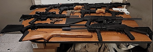 Displayed on a table are 12 weapons of various calibers seized by CBP officers at Eagle Pass Port of Entry.