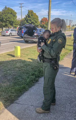 Female Border Patrol agent holds infant rescued from attempted abduction