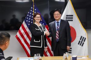 Executive Assistant Commissioner AnnMarie Highsmith shakes hands with a Korean delegate.