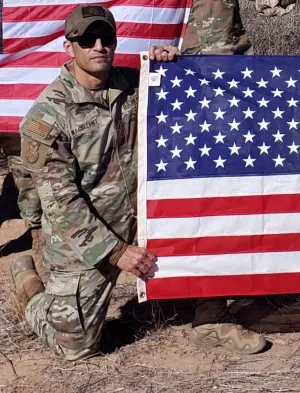 Gilbert Magallanez in military uniform holding American flag