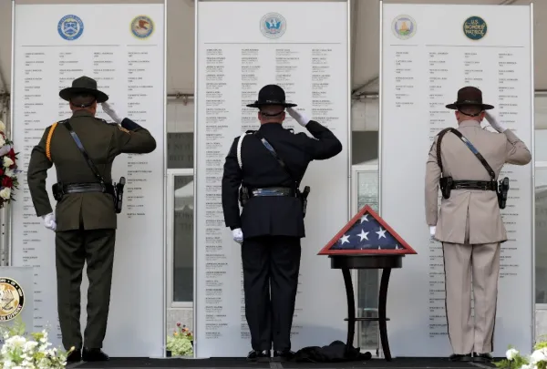 Members of the CBP Honor Guard salute the names of the fallen on the Valor Memorial.