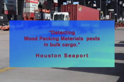 Detecting Wood Packaging Material in Bulk Cargo Title with a shot of a seaport in the background. containers, and truck moving a container.