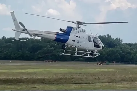 An AMO helicopter flies low to the ground