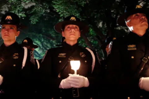 3 CBP officers hold candles at the 2018 National Police Week Candlelight vigil