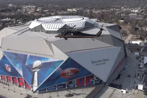A CBP AMO helicopter flies in front of Atlanta's Mercedes-Benz Stadiuim