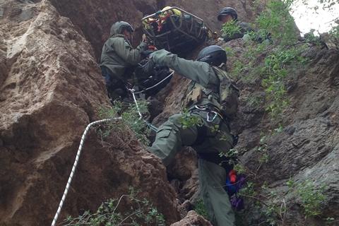 Miembros del  Equipo de Búsqueda, Trauma y Rescate de la Patrulla Fronteriza (BORSTAR) rescatan a un migrante en un acantilado. 