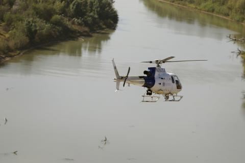 An Air and Marine Operations AS350 crew flies over the Rio Grande River 