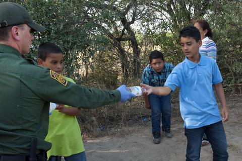 Border Patrol agent distributes water.