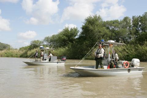 U.S. Border Patrol Marine units face toward Mexico to provide cover for other agents on the U.S. side of the river