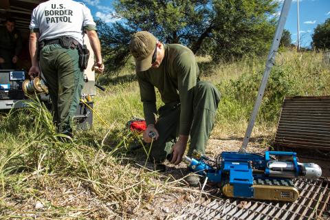 A Border Patrol agent prepares a robot to explore an underground drainage pipe for signs of illegal activity by smugglers.