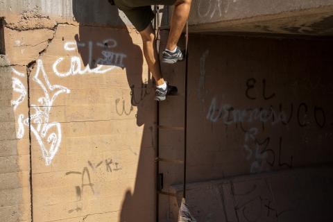 Border Patrol agent climbing down ladder at Nogales.