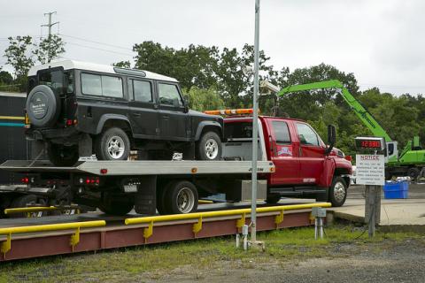Land Rover sitting on back of the tow truck awaiting destruction.