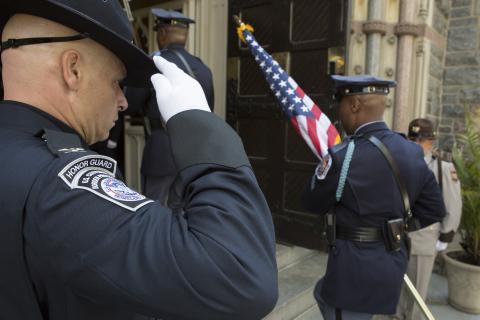 CBP honor guard member salutes flag.