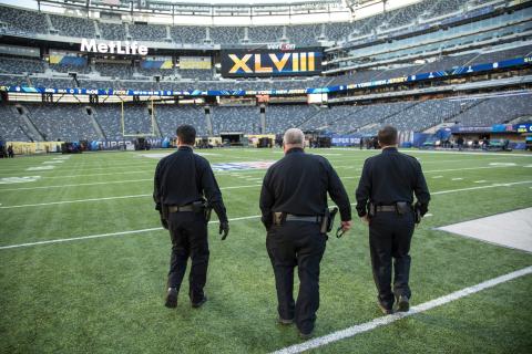 Three CBP Officers walk the field to prepare for security