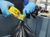 A CBP officer seals a bag with hazardous items.