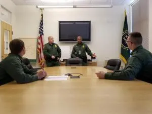 Border Patrol Academy trainees Thomas Gursky (far left) and Justin Franklin (far right) listen as Patrol Agent in Charge Jarom Linde and Supervisory Border Patrol Agent Shelton McKenzie brief them on what they’ll be doing at the Orlando, Florida, Border Patrol station. Photo by Supervisory Border Patrol Agent Richard Torres  