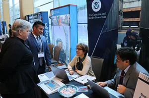 Symposium participants discuss quotas at one of the CBP booths