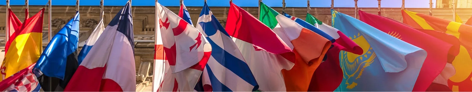 Multiple international flags displayed outside a building