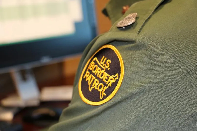 Border Patrol agent performing immigration check on computer