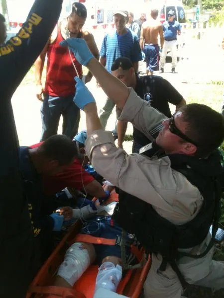 A CBP EMT administers an an intravenous serum to the injured swimmer.