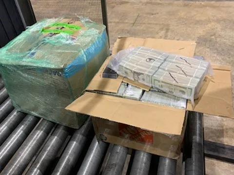 Vacum sealed packs of dollars were found inside palleted moving boxes. 