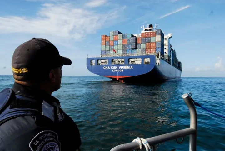 CBP officer observes a cargo ship docking in the United States. 