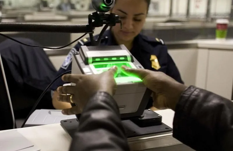 A Customs and Border Protection officers uses a fingerprint scanner.