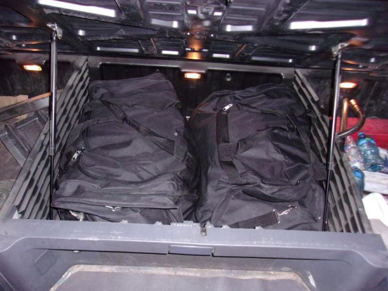 Inside, the CBP officer lifted the sleeper compartment and found two black duffel bags hidden inside.  