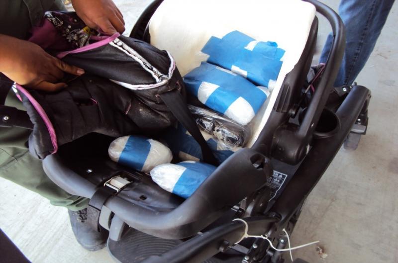 A K-9 alert led agents to 23 packages of narcotics hidden in a child’s car seat and stroller.