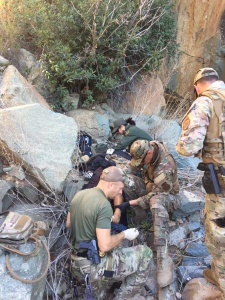 Agents render aid to a woman who fell into a rocky canyon resulting in serious injuries