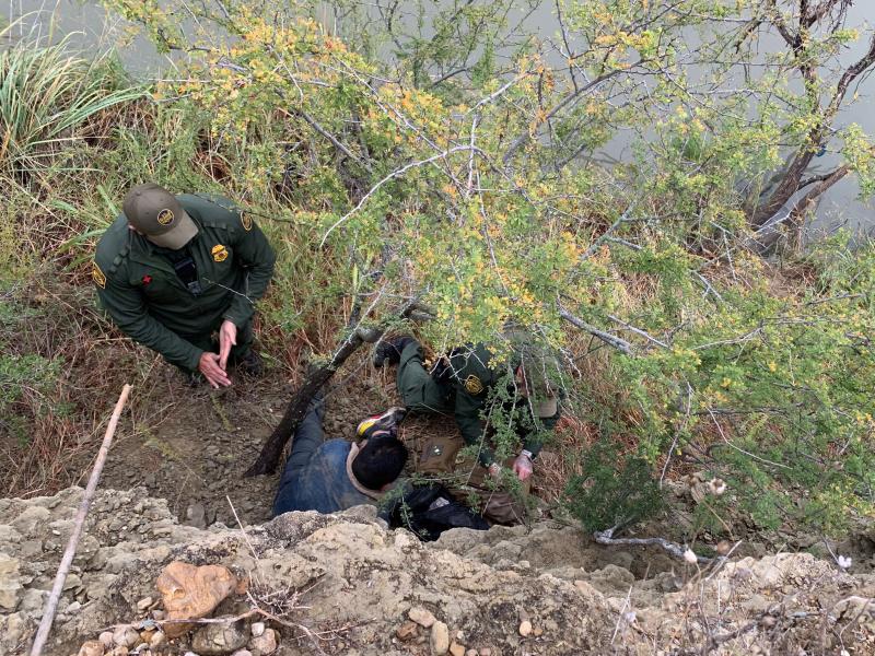 Agents assist a migrant who fell off a cliff.