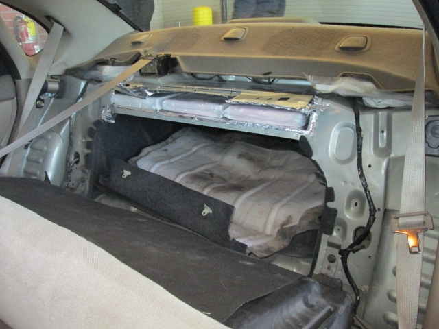 Cocaine bundles visible in hidden compartment.