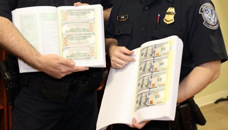 CBP officers find counterfeit currency taped to the inside pages of a book.