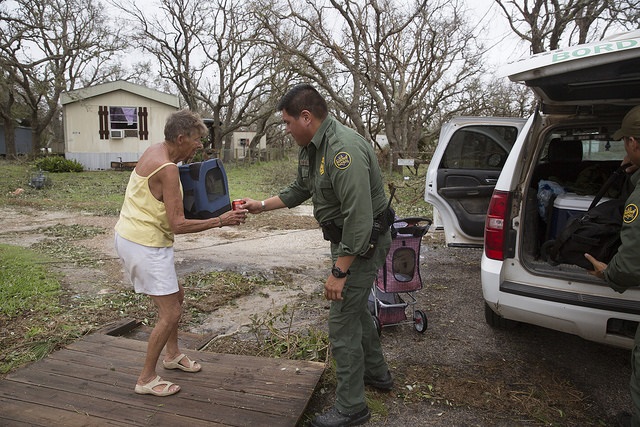 U.S Border Patrol agent Mario Fuentes rolls the belonging of a disaster survivor to a bus to evacuate her and her dog Chester in the wake of Hurricane Harvey.